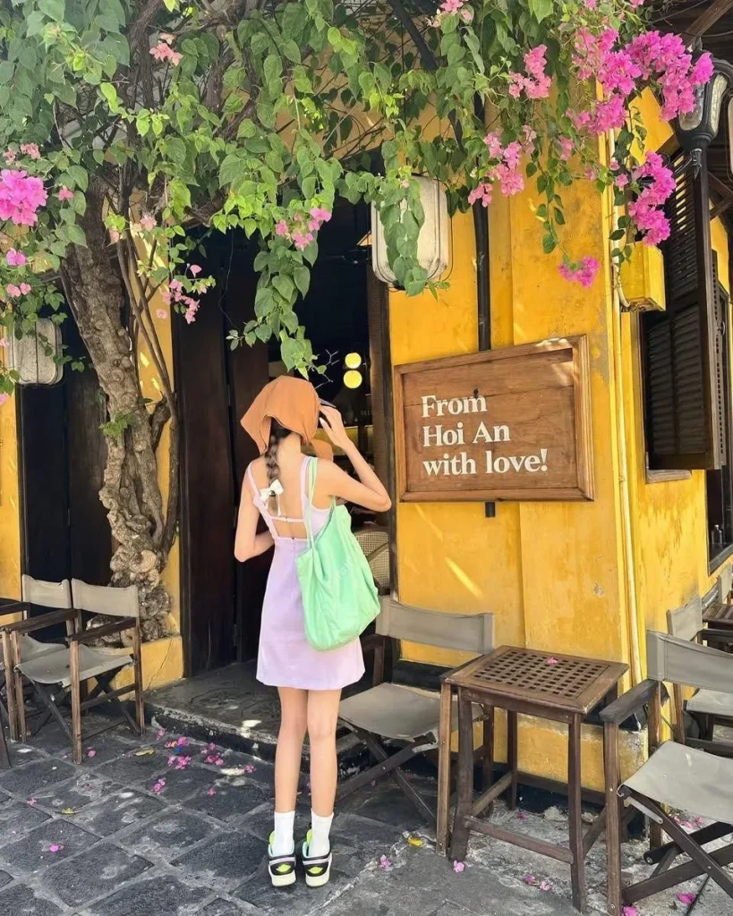 Góc check-in quen thuộc với bức tường vàng đặc trưng và giàn hoa giấy hồng rực rỡ tại Hội An